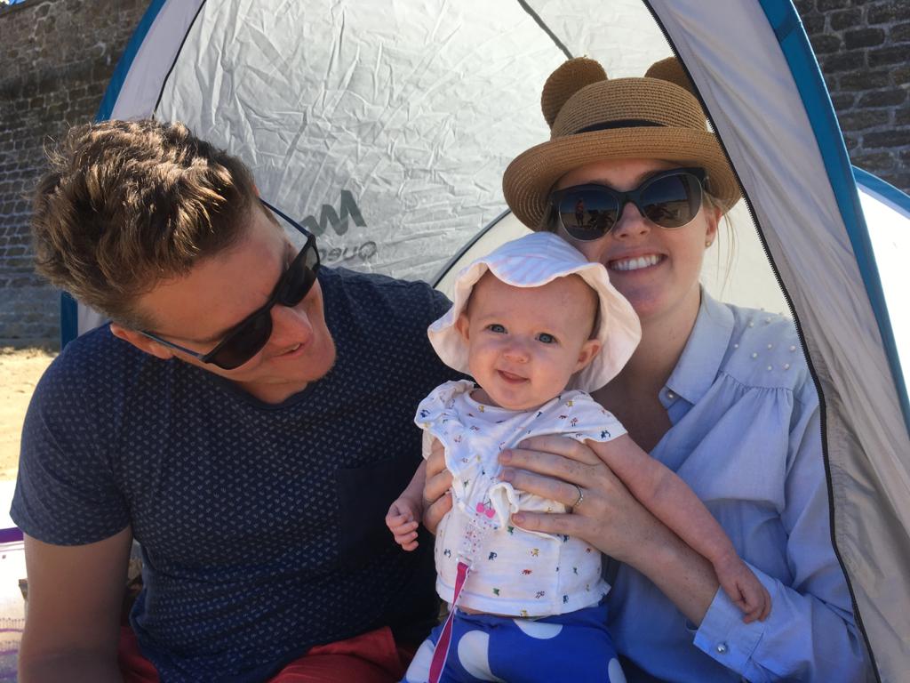 Parents in shade on beach with baby